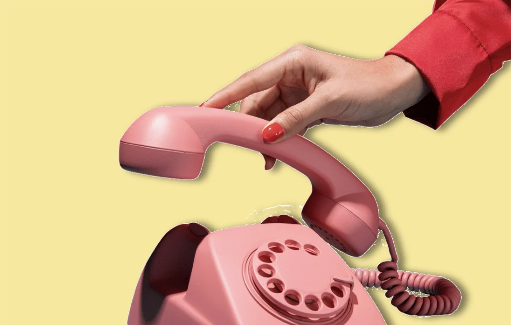 Main qui décroche un vieux téléphone rose